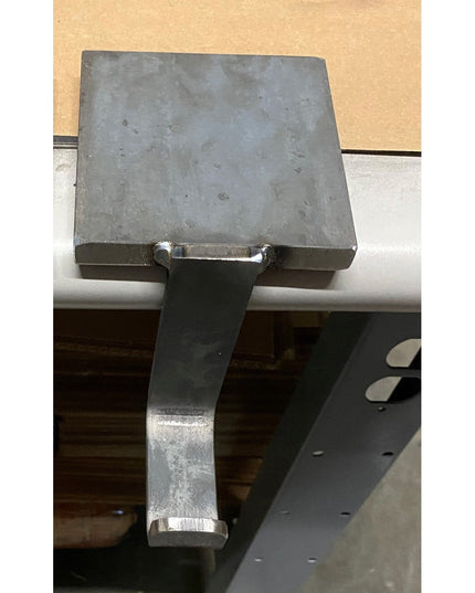 Industrial Farm Co Annie Stocking Holder in weathered gray metal with curved hook arm mounted on white shelf against beige...