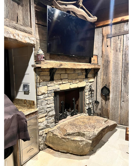 Rustic stone fireplace with reclaimed wood mantel featuring Little Falls Metal Corbel brackets by Industrial Farm Co in fa...