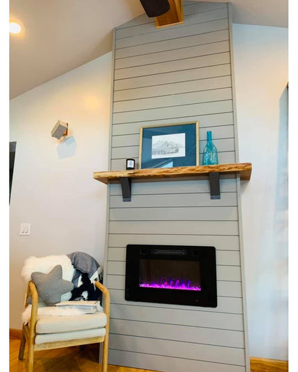 Black metal Jeffery Style Shelf Brackets by Industrial Farm Co supporting rustic wood mantel above modern electric fireplace