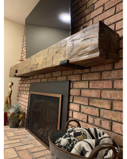 Rustic wooden beam mantel with weathered finish mounted on brick fireplace using black metal Glimmerglass J Shelf brackets...
