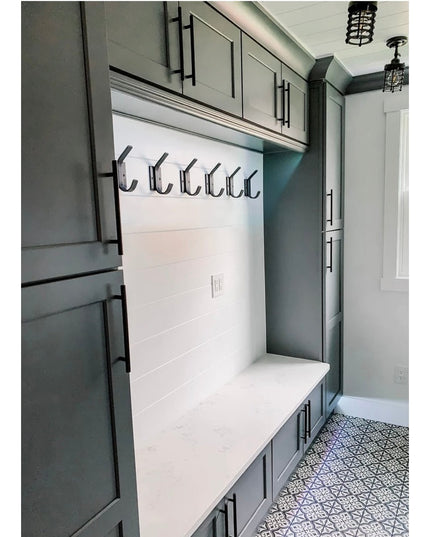 Black metal Elizabeth Wall Hooks by Industrial Farm Co mounted on white shiplap mudroom wall with sage green built-in stor...