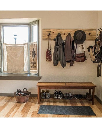 Rustic wooden wall-mounted coat rack with multiple hooks holding jackets, bags, and hat in modern farmhouse entryway - The...
