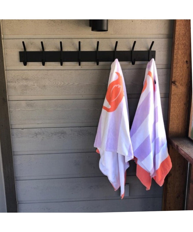 Black metal Cooperstown Double Hook Coat Rack mounted on gray shiplap wall with colorful tea towels hanging from two hooks