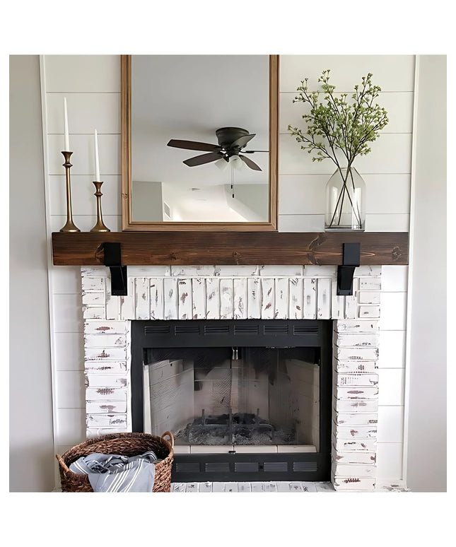 Black metal Seneca 3" Farmhouse Mantel Brackets supporting dark wood beam above white distressed brick fireplace by Indust...