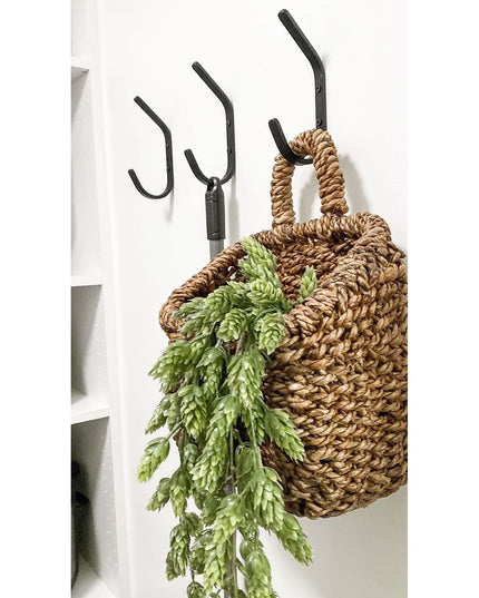 Black iron Stewart 1/2" Wide Double Hook mounted on white wall with woven basket and green fern, Industrial Farm Co wall hook