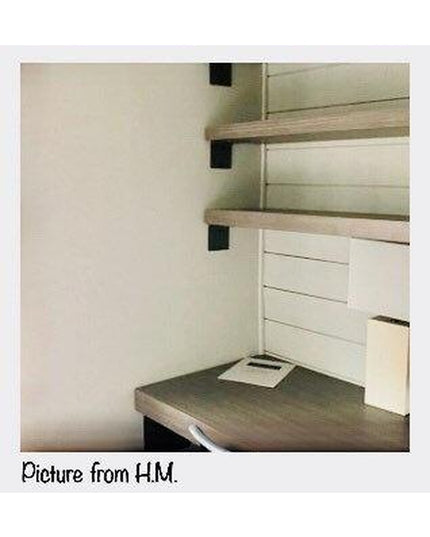 Black steel Lorraine L shelf brackets supporting natural wood floating shelves in white modern interior with built-in desk...