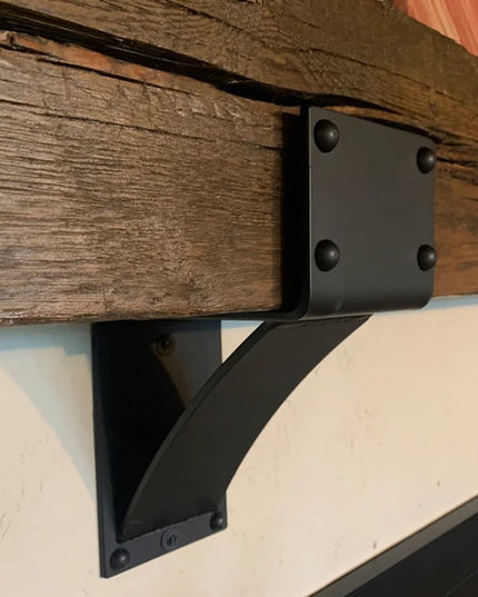 Heavy duty black steel Mottville 5" mantel bracket with decorative rivets mounted under rustic wooden beam by Industrial F...