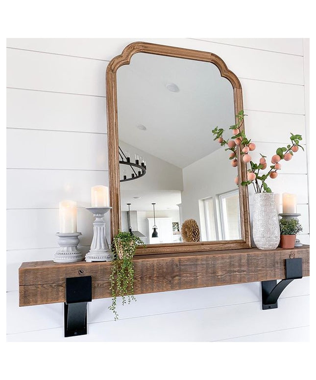 Kudlick Farmhouse wooden mantel shelf with black metal brackets mounted on white shiplap wall, decorated with mirror, cand...