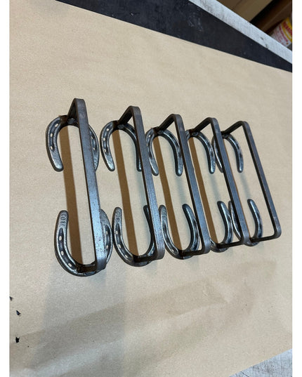 Black wrought iron horseshoe door handle by Industrial Farm Co featuring five connected horseshoes in rustic handforged st...