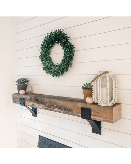 Clermont 4 inch black steel mantel brackets with rivets supporting reclaimed wood beam shelf above white shiplap fireplace...