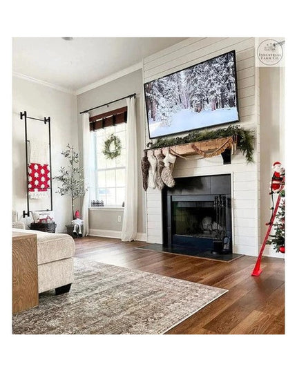 Black metal wall mounted Ossit ladder by Industrial Farm Co displaying red patterned throw blanket in cozy farmhouse livin...