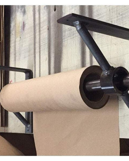 Black metal Glen Cove Modern Shelf Support by Industrial Farm Co mounted on wall holding kraft paper roll in rustic worksh...