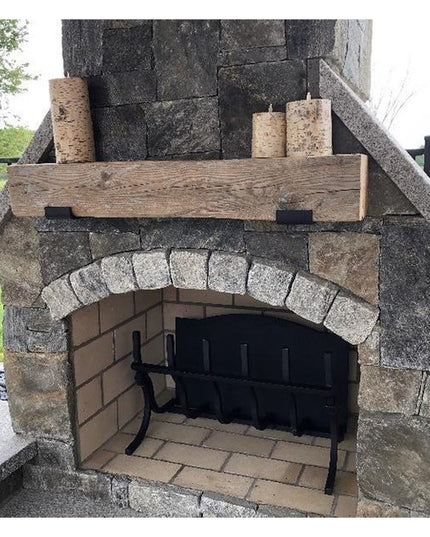 Industrial Farm Co Glimmerglass J Shelf Bracket supporting rustic wooden mantel on stone outdoor fireplace with candles