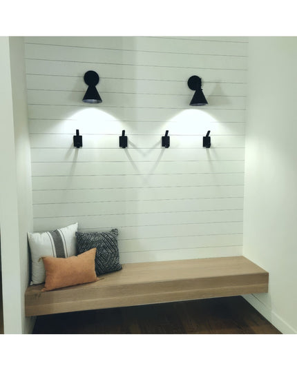 Black metal Elizabeth Wall Hooks by Industrial Farm Co mounted on white shiplap wall above wooden bench with pillows and s...