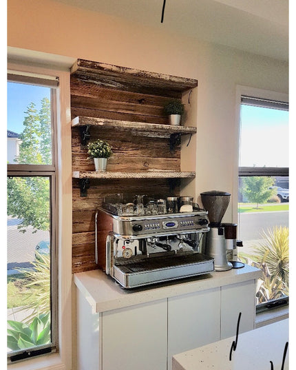 Black metal Glen Cove Modern Shelf Support brackets holding reclaimed wood shelves above espresso machine in rustic kitche...