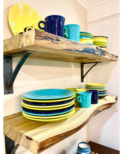 Heavy duty steel industrial shelf brackets supporting reclaimed wood shelves with colorful ceramic dishes and mugs in rust...