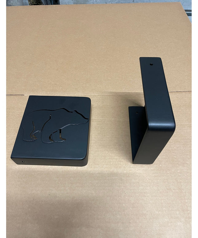 Black steel Vandiver Bear Mantel End Caps by Industrial Farm Co with engraved polar bear design on cardboard surface
