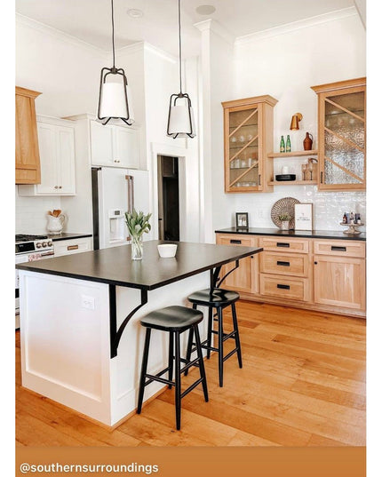 Black metal Syracuse countertop support brackets from Industrial Farm Co holding up kitchen island with dark countertop an...