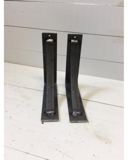 Two black steel curved industrial shelf brackets with mounting holes on white wood background, heavy duty handmade design ...