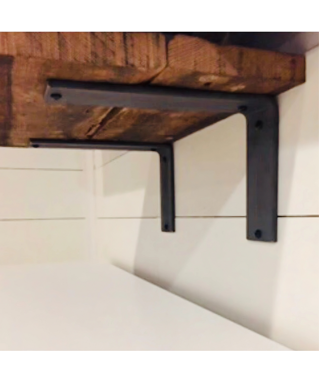 Black metal shelf bracket attached to a wooden shelf against a white wall.