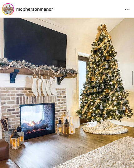 Living room with a Christmas tree, fireplace, and stockings.