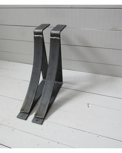Two black metal Marietta Shelf and Mantle Support brackets with curved design on white wooden planked background by Indust...