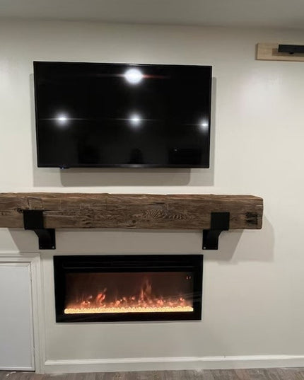 Heavy duty black metal Fulton Style mantel brackets supporting rustic wood beam above modern electric fireplace with wall-...