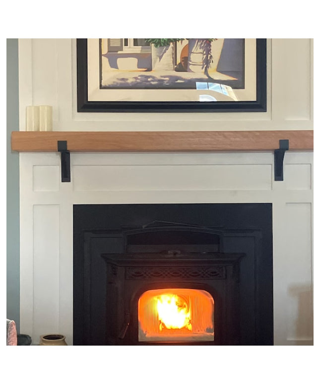 Black metal Saratoga Shelf Support Brackets by Industrial Farm Co supporting natural wood mantel above white fireplace