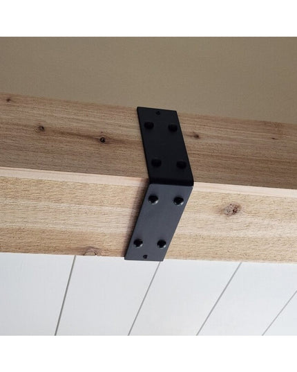 Black metal L-shaped beam strap bracket mounted on natural wood ceiling beam with white shiplap wall below - The Billings ...