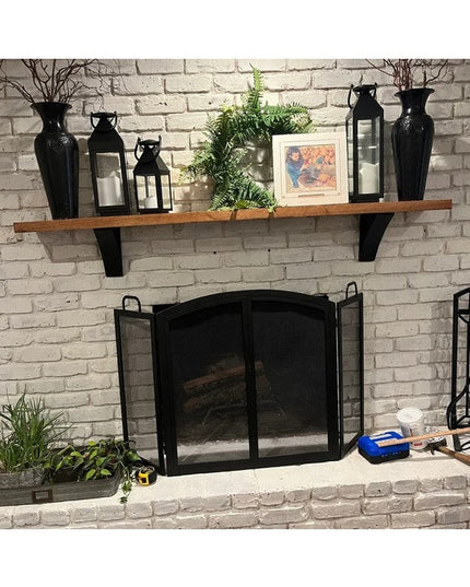 Black metal Eleanor Minimal Steel Brackets supporting wooden mantel shelf above white brick fireplace with decorative vase...