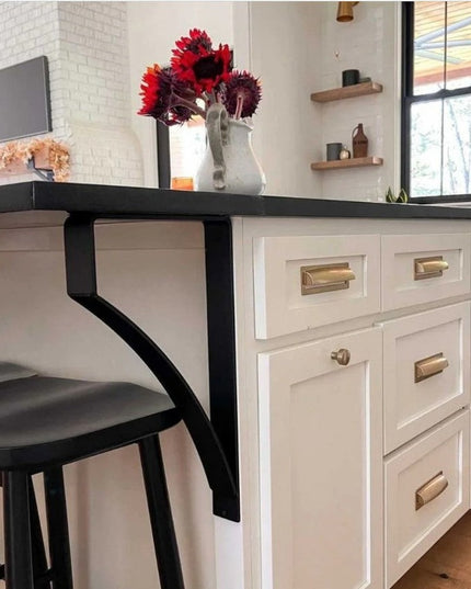 Black metal Syracuse countertop support brackets from Industrial Farm Co supporting dark countertop overhang in modern whi...