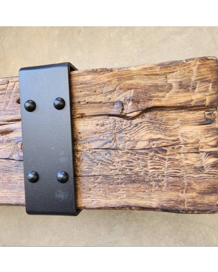 Rustic wooden beam with black metal Industrial Farm Co Billings beam strap featuring four rounded bolts on weathered wood