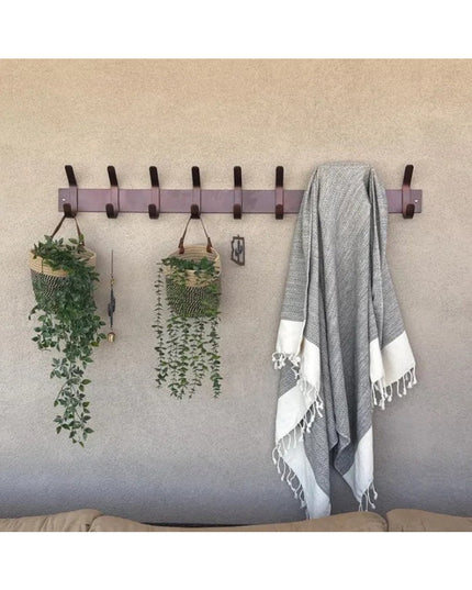 Industrial Farm Co Fairmount Style wall-mounted coat rack with purple wood base and dark hooks displaying hanging plants a...