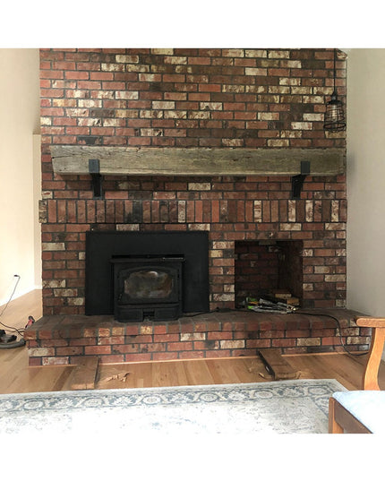 Rustic brick fireplace featuring weathered wood mantel supported by black metal Seneca 3" Farmhouse Mantel Brackets from I...