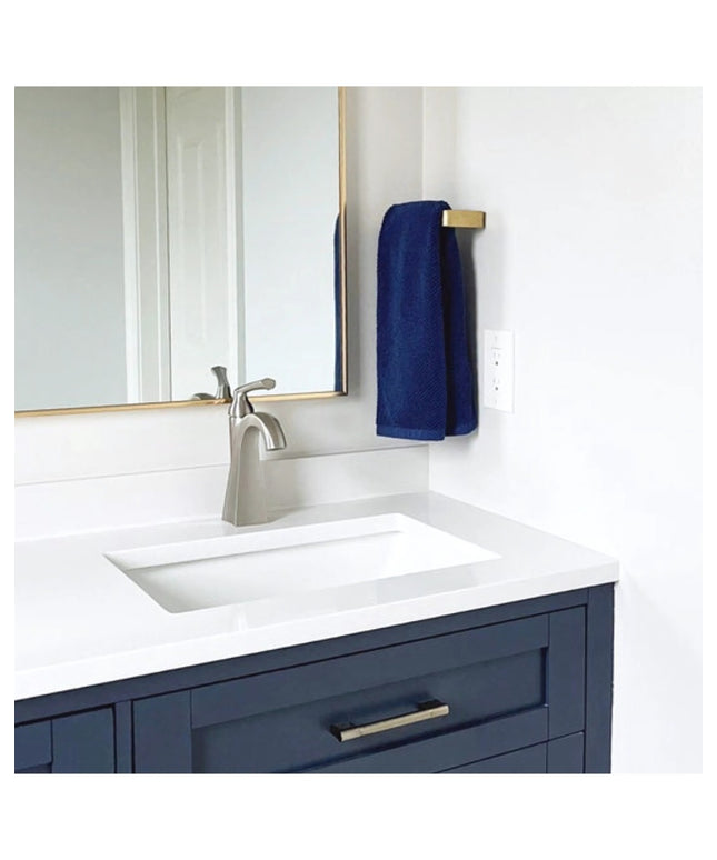Modern bathroom vanity featuring navy blue cabinets with brass Emma Towel Holder by Industrial Farm Co, white countertop a...