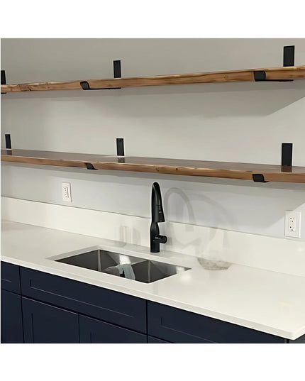 Black metal J-style shelf brackets supporting natural wood shelves in modern kitchen with navy cabinets and white countertops