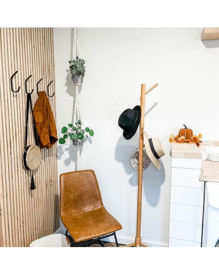 Black metal Stewart 1/2" Wide Double Hook mounted on light wood slat wall in modern entryway with brown leather chair and ...