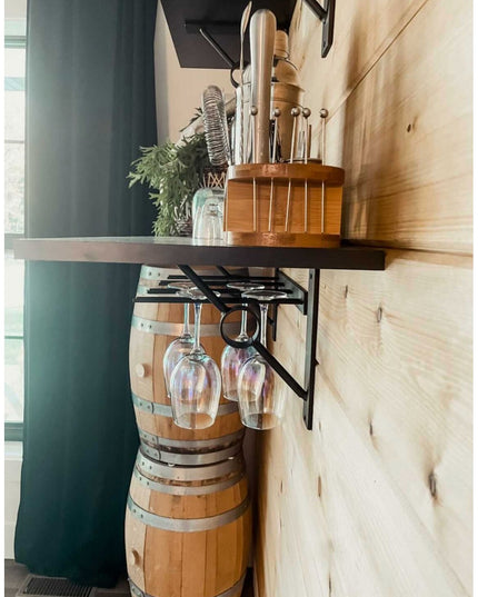 Black metal Glen Cove Modern Shelf Support by Industrial Farm Co holding wine glasses under wooden shelf with barrel and k...