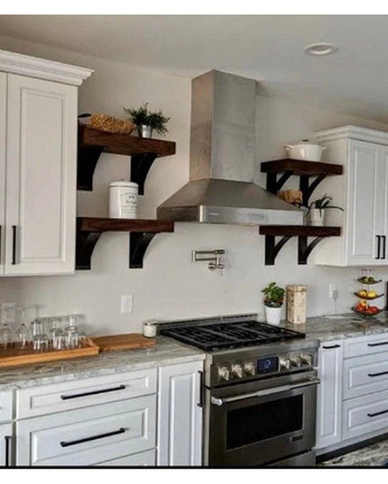 The Andrew Countertop Support black metal brackets holding dark wood shelves in white farmhouse kitchen with stainless ste...