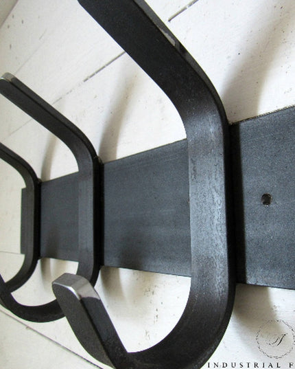 Black metal Fairmount Style wall-mounted coat rack with curved hooks by Industrial Farm Co against white shiplap wall