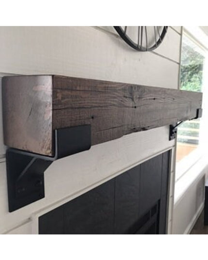 The Fulton Style Heavy Duty Mantel Support black metal brackets supporting rustic wood beam mantel above white fireplace b...