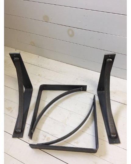 Black steel industrial shelf brackets with curved support bars from Industrial Farm Co displayed on white wooden planks