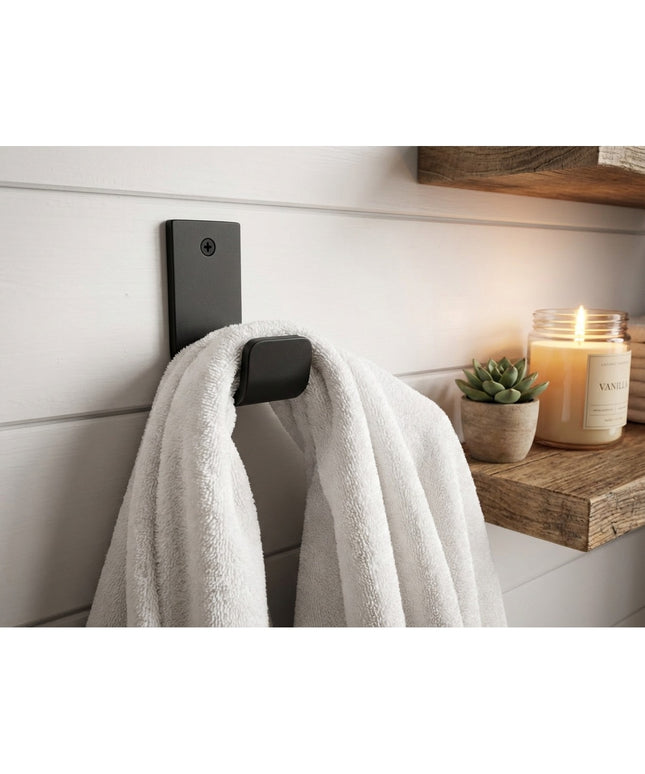 Black metal Western Ridge 1.5" J Wall Hook by Industrial Farm Co mounted on white shiplap wall holding white towel with ca...