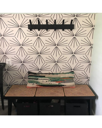 Black metal Fairmount Style Coat Rack with 6 hooks mounted on geometric patterned wall above wooden cane bench with woven ...