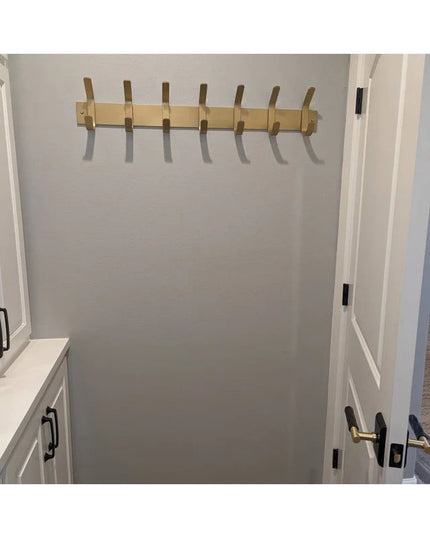 Fairmount Style Coat Rack by Industrial Farm Co mounted on white closet wall with 7 wooden pegs and light wood finish