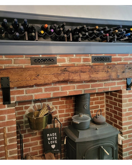 Heavy duty black steel Spafford mantel bracket with rivets supporting rustic wood beam on brick fireplace by Industrial Fa...