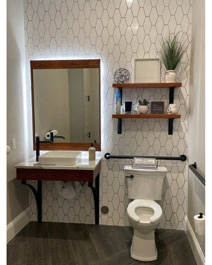 Syracuse black metal countertop support brackets holding wood vanity in modern bathroom with hexagon tile wall - Industria...