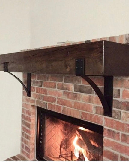 Black steel Spafford mantel brackets with rivets supporting rustic wood beam above brick fireplace by Industrial Farm Co