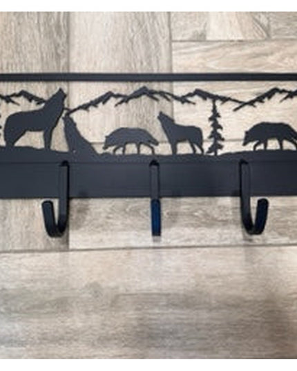 Black metal wall-mounted coat rack featuring wolf and wildlife silhouettes with mountain landscape design, 5 hooks by Indu...